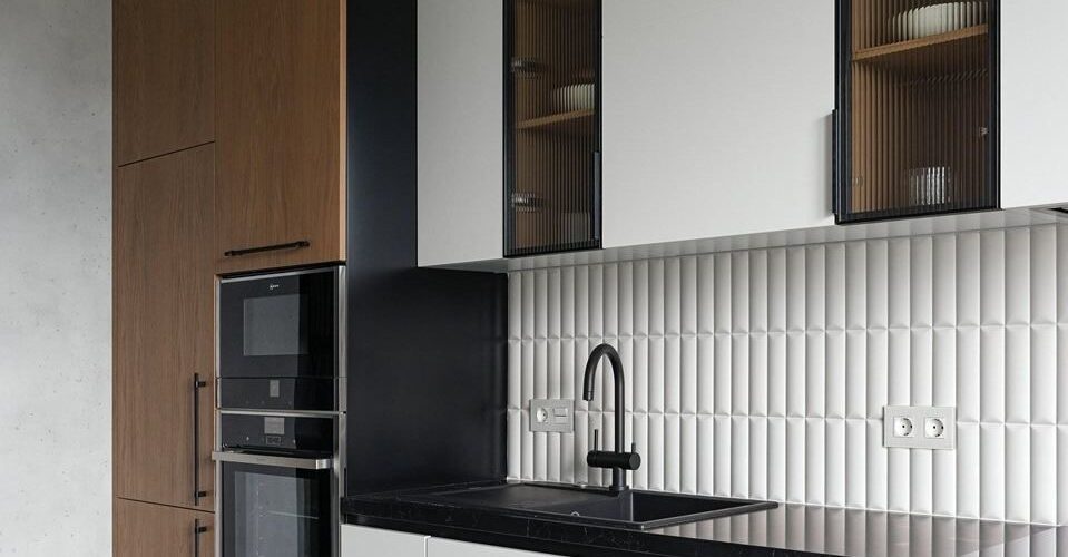 کابینت آشپزخانه مدرن با ترکیب چوب و ام‌دی‌اف سفید، صفحه سنگ مشکی و کاشی بین کابینتی طرح سه‌بعدی